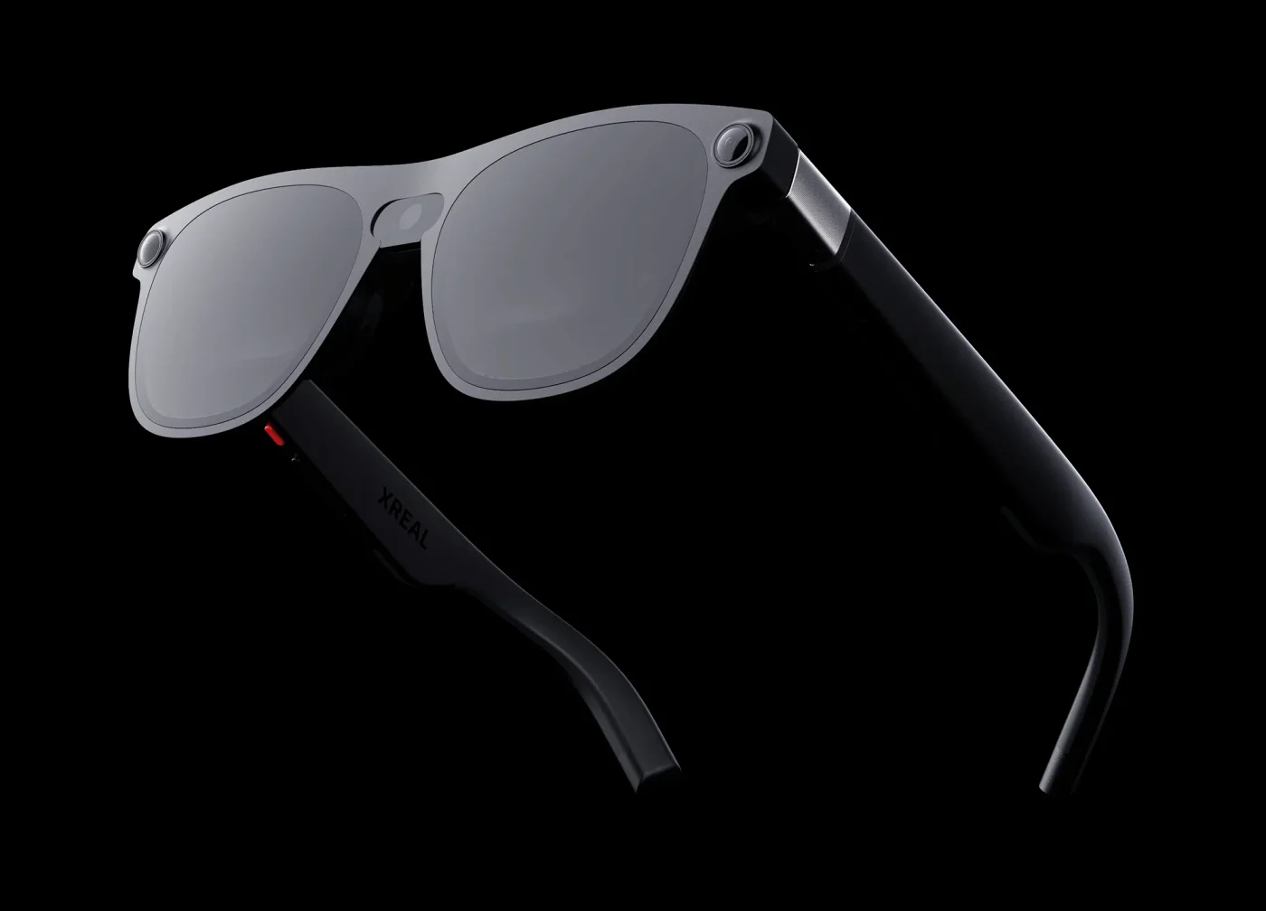 XREAL AURA glasses on a black background: a silver front frame with smoked see-through lenses, small sensors at each corner, and black temple arms with the XREAL name on the side